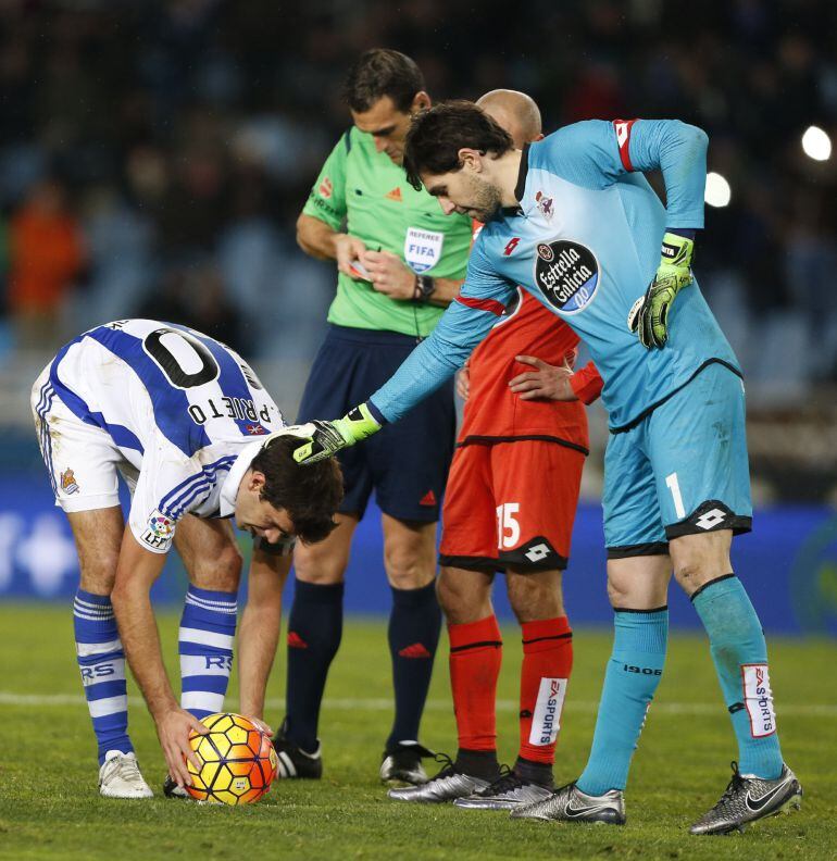 El jugador de la Real Sociedad Xabi Prieto (i) prepara el balón para lanzar un penalti junto al guardameta argentino Germán Lux (d), del Deportivo de La Coruña, durante el partido disputado en el estadio de Anoeta, en San Sebastián