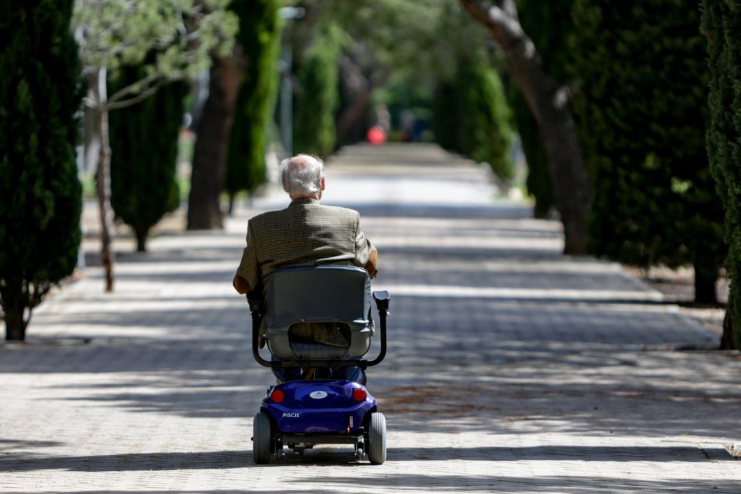 Un anciano en silla de ruedas eléctrica 