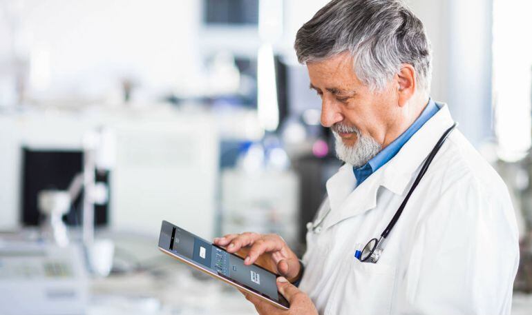 Médico utiliza una tablet.