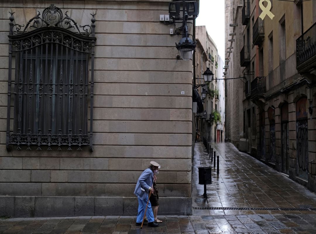 Una mujer con mascarilla por las calles de Barcelona.