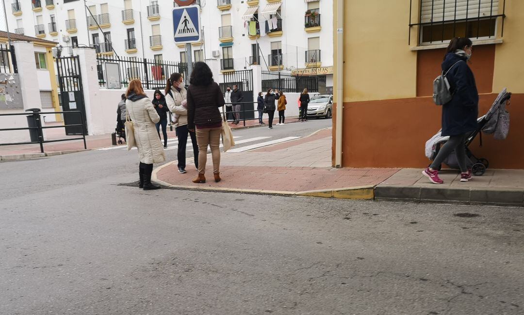 Un grupo de personas esperan la salida de clase de los alumnos 