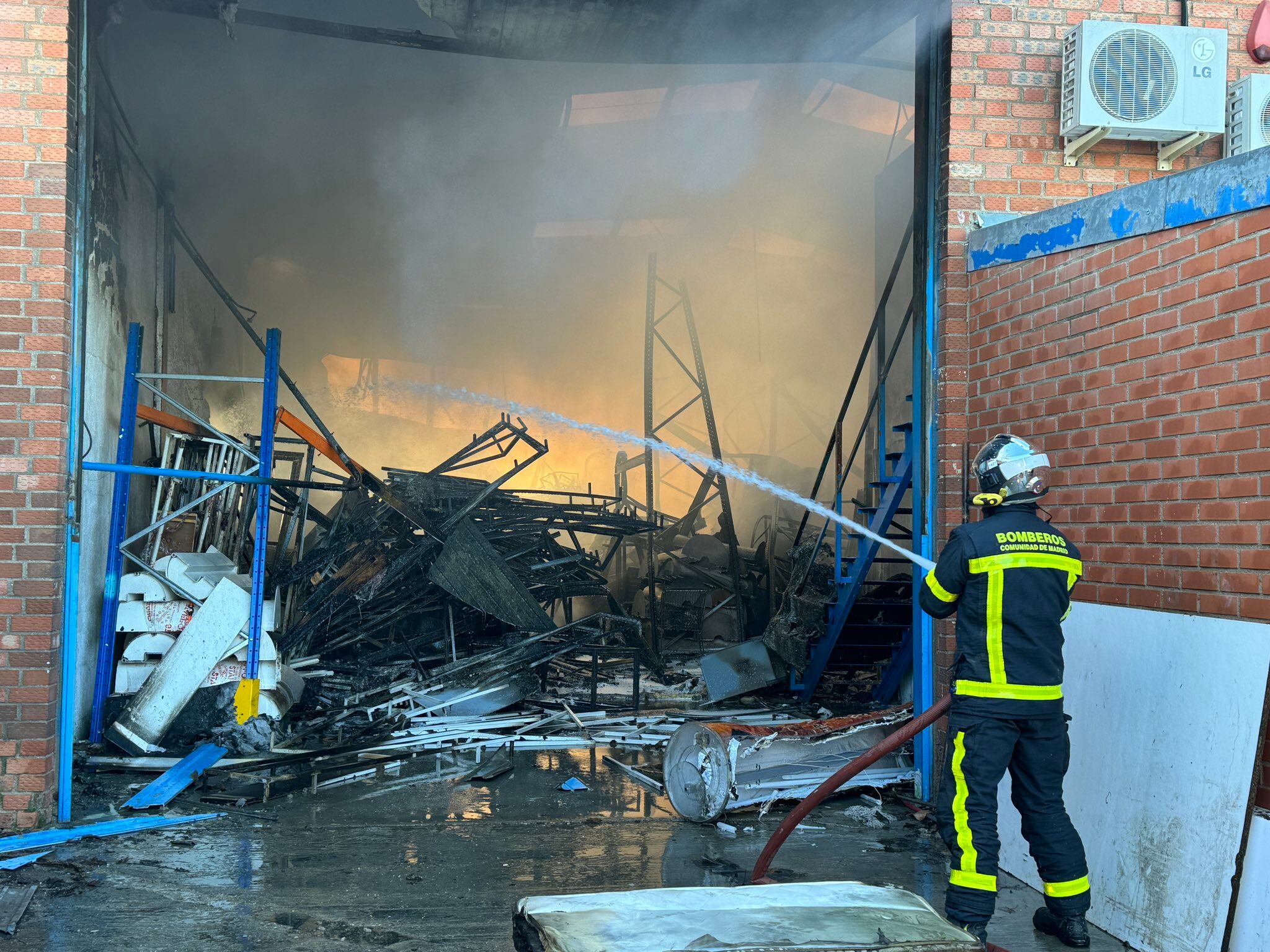 Doce dotaciones de bomberos de la Comunidad de Madrid lograron evitar la propagación del fuego a la zona delantera de las naves, en las que no se han producido heridos