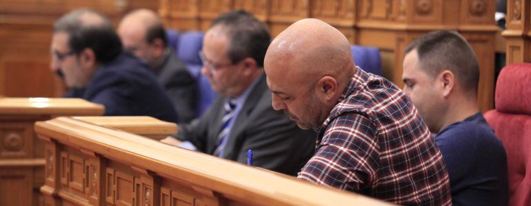 En primer plano de la imagen, los diputados de Podemos José García Molina y David Llorente y al fondo, miembros del gobierno de Castilla-La Mancha