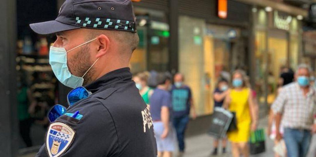 Un agente con mascarilla en el centro de la ciudad