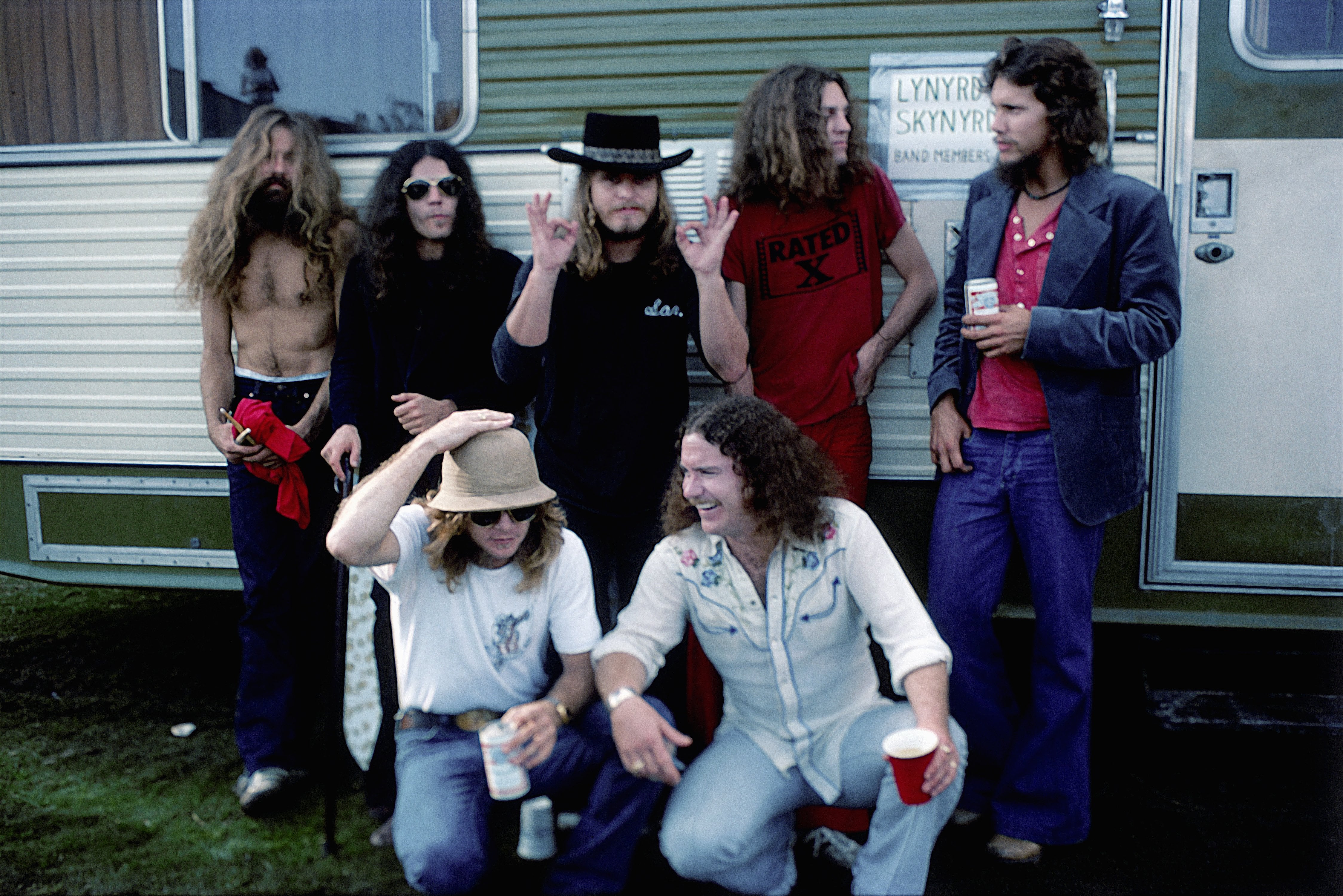 CALIFORNIA - OCTOBER 1976: Southern Rock band Lynyrd Skynyrd (L-R back row Artimus Pyle, Gary Rossington, Ronnie Van Zant, Allen Collins and Steve Gaines, front row Leon Wilkeson and Billy Powell) pose by their trailer backstage at an outdoor concert in October, 1976 in California. (Photo by Michael Ochs Archives/Getty Images)