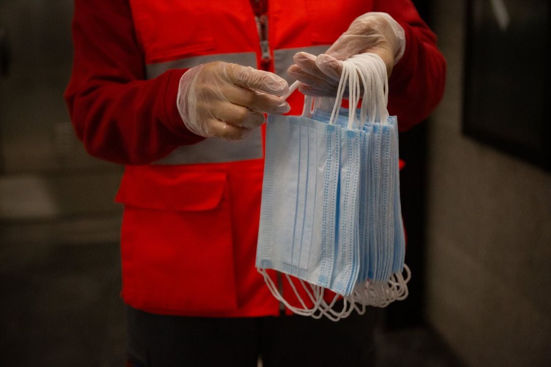 Una voluntaria de Cruz Roja se prepara para entregar mascarillas 