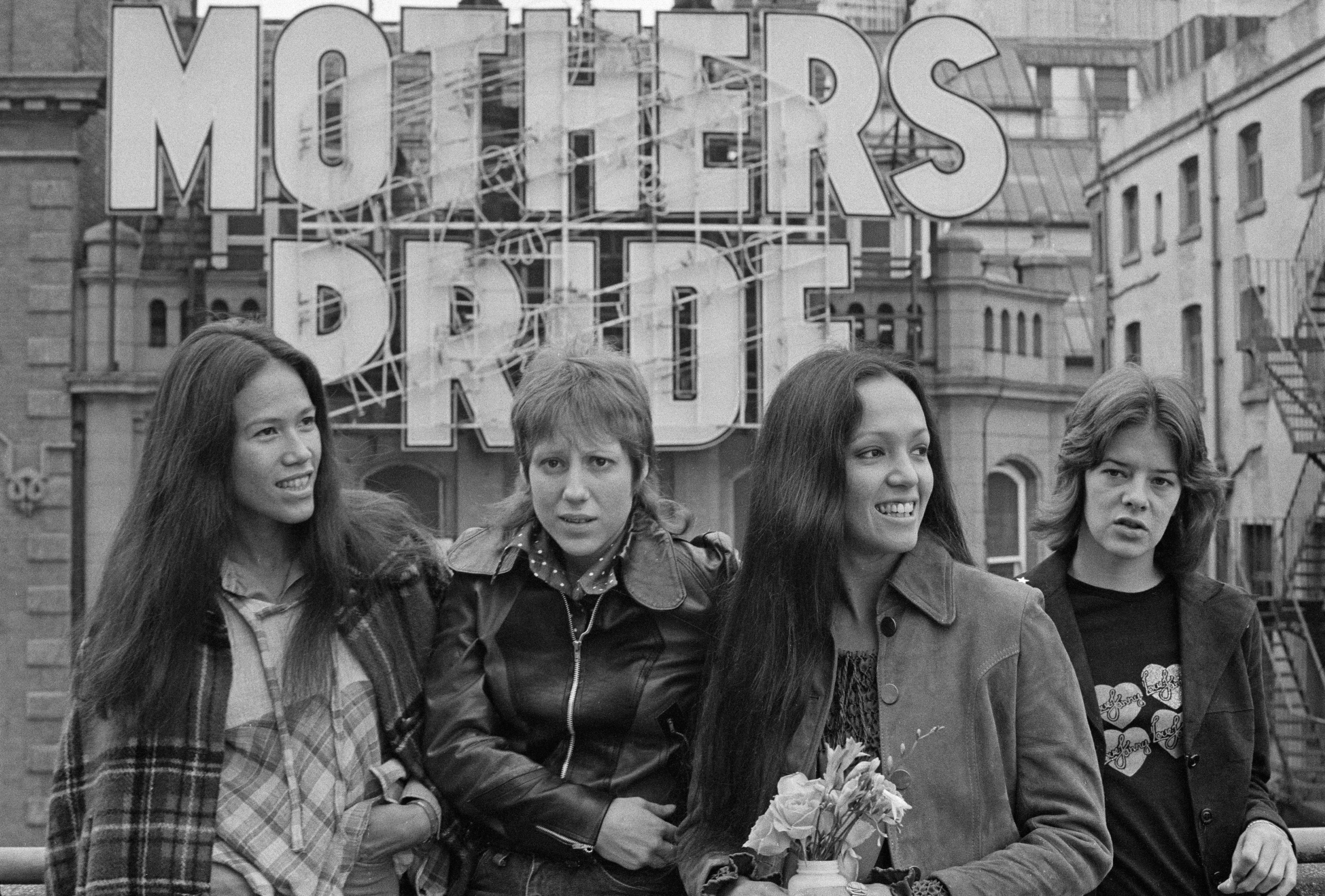 American all-female rock group Fanny during a tour, 17th October 1972. Left to right: guitarist June Millington, keyboard player Nickey Barclay,  bassist Jean Millington and drummer Alice de Buhr. They are standing in front of a sign advertising Mother&#039;s Pride bread - &#039;Mother&#039;s Pride&#039;, also being the title of the band&#039;s fourth album. (Photo by Michael Putland/Getty Images)