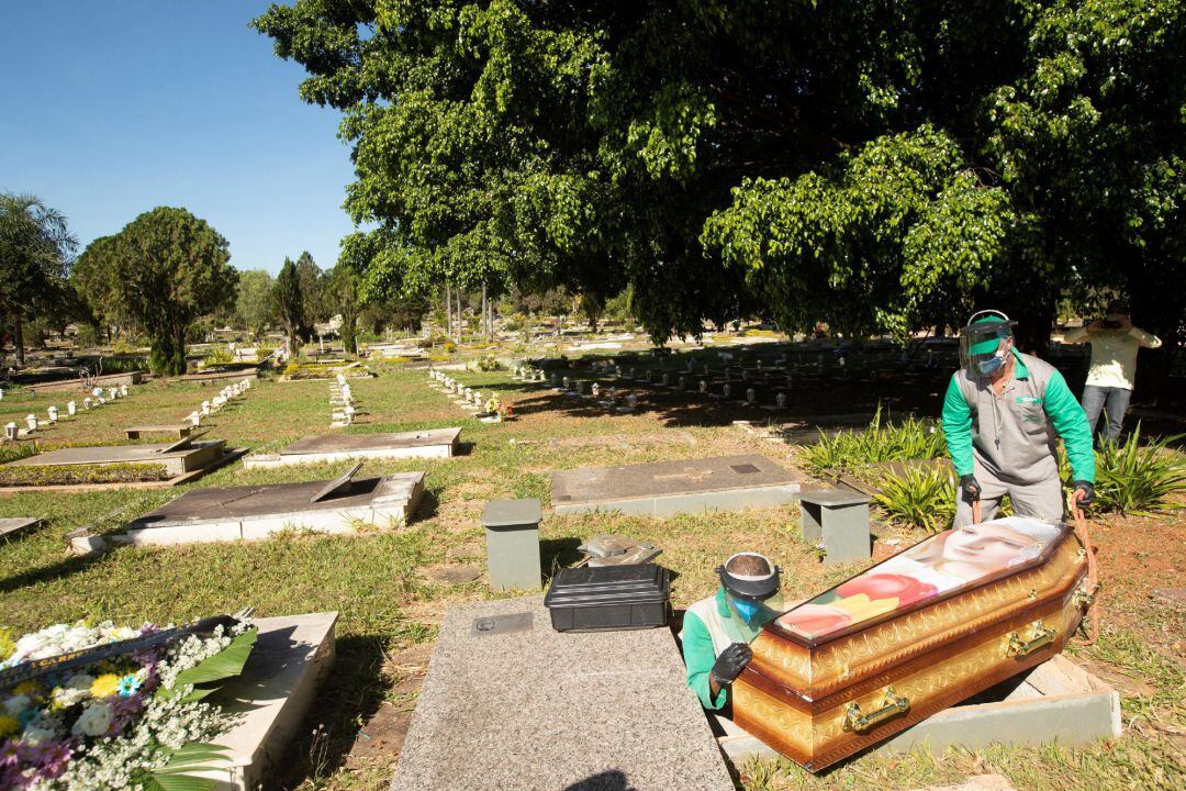 Trabajadores del cementerio Campo de Esperanza entierran una víctima de coronavirus en Brasilia (Brasil)