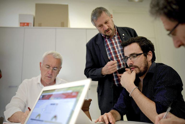 El líder de IU, Cayo Lara (i), y el candidato a la presidencia del Gobierno, Alberto Garzón (d), acompañados por el exeurodiputado Willy Meyer, siguen la información de la jornada electoral en la sede de Izquierda Unida, en Madrid.