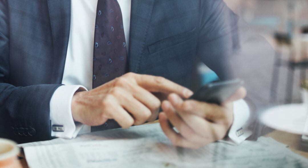 Un hombre mira el móvil en un bar