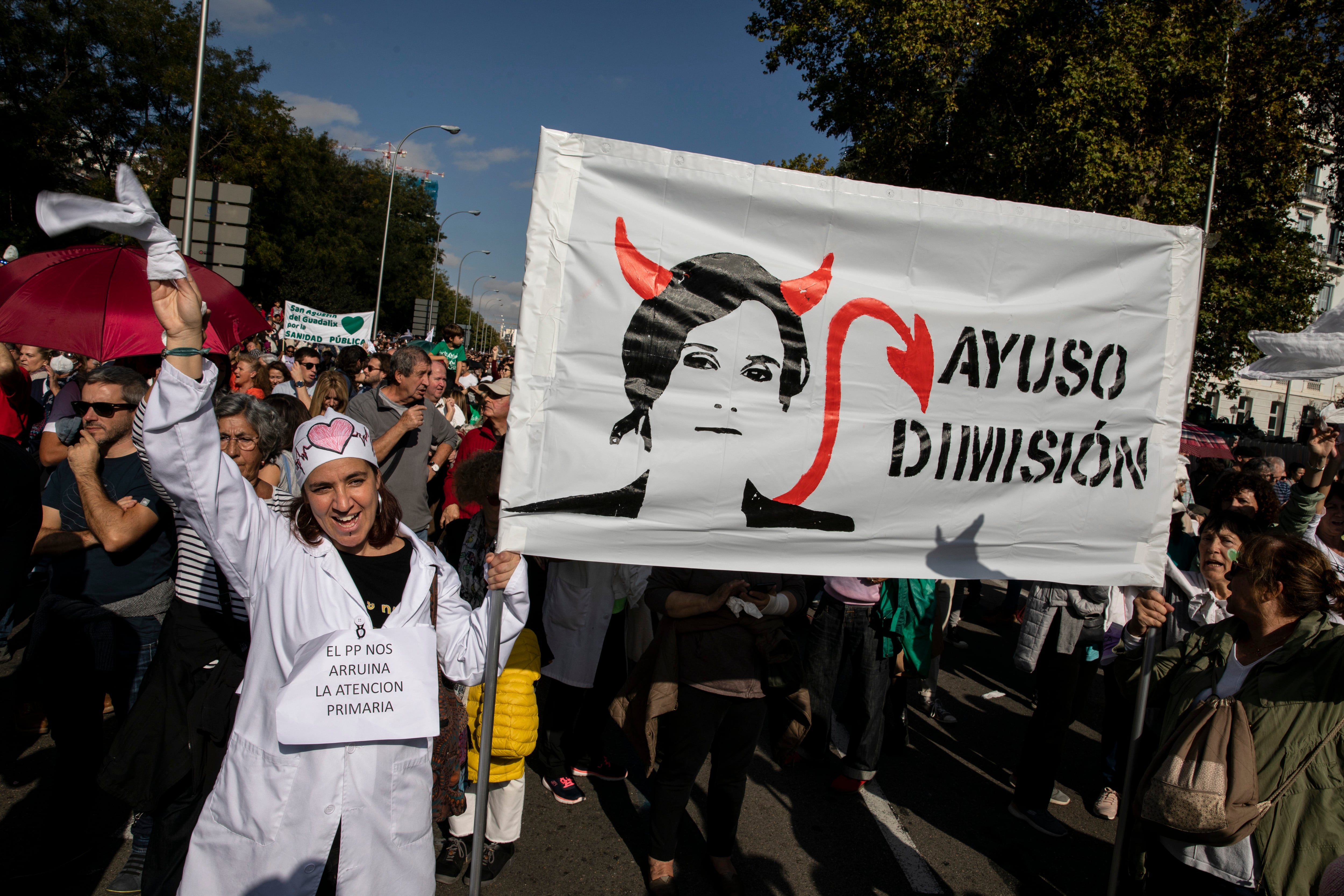 Una manifestante sostiene una pancarta que pide la dimisión de la presidenta de la Comunidad de Madrid, Isabel Díaz Ayuso, el pasado 13 de noviembre