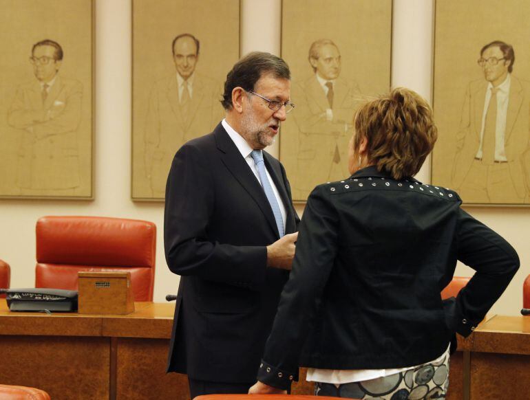 El presidente del Gobierno en funciones, Mariano Rajoy, conversa con la diputada popular Celia Villalobos, al inicio hoy de la reunión plenaria del Grupo Popular en el Congreso de los Diputados. 