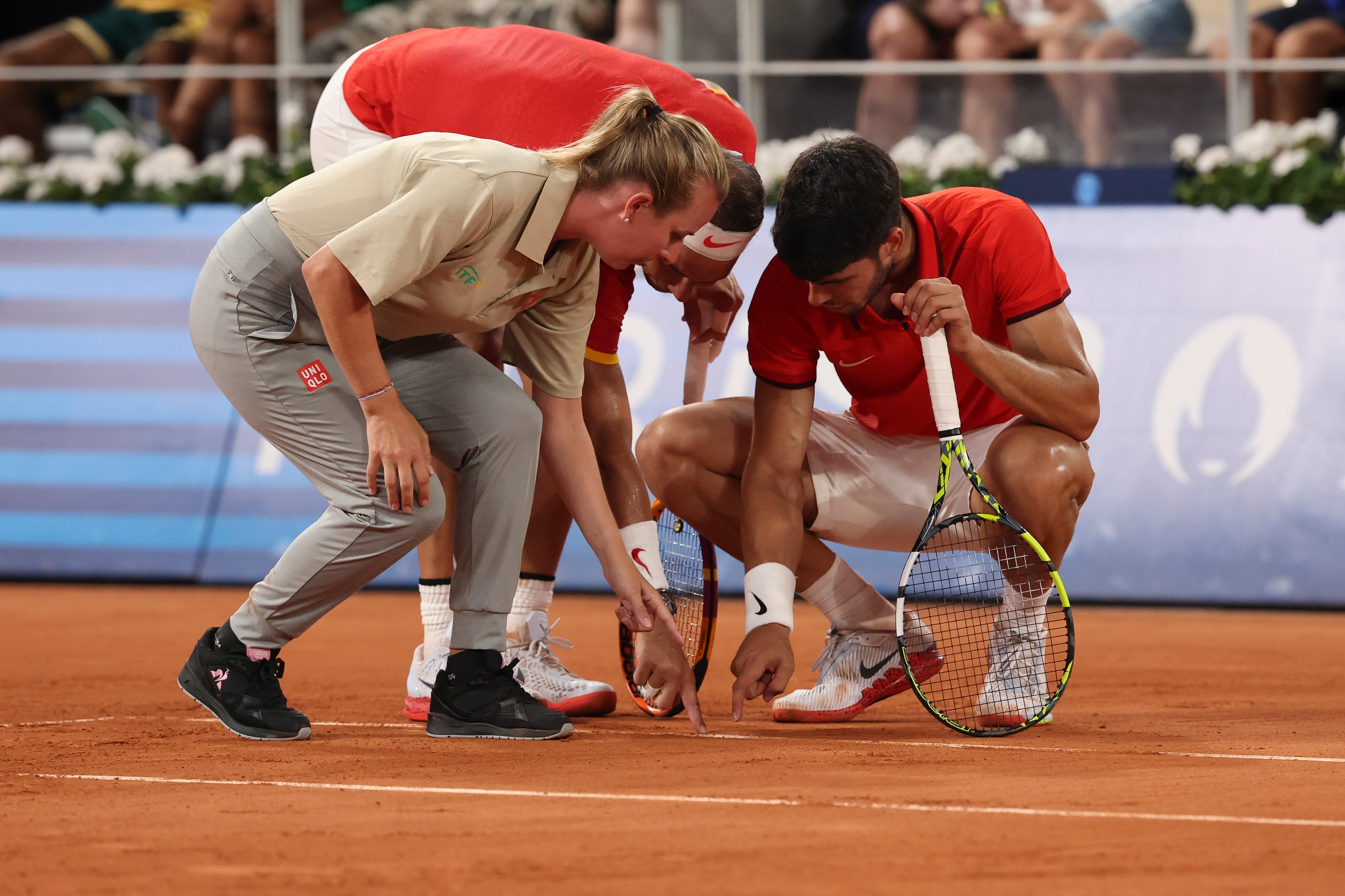 Los tenistas españoles Rafa Nadal y Carlos Alcaraz conversan con la juez de línea durante los cuartos de final. EFE/ Juanjo Martín