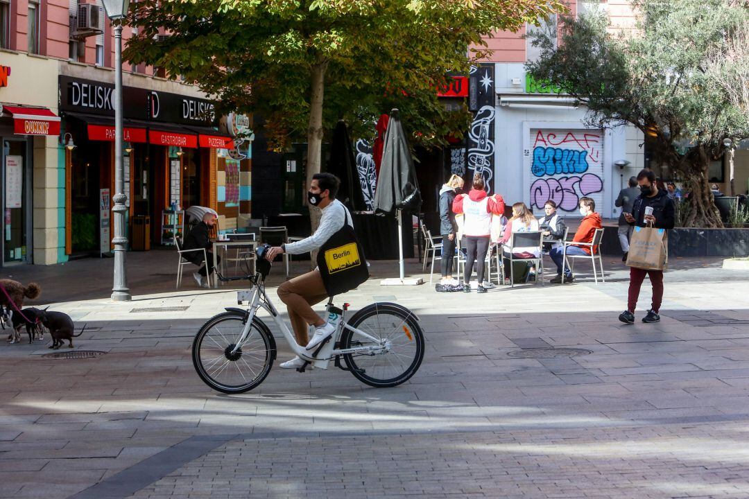 Un hombre pasea en bicicleta por la céntrica calle de Fuencarral, en Madrid (España).