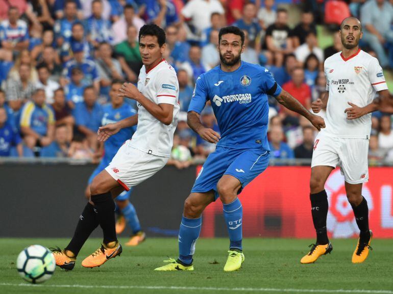 El centrocampista brasileño del Sevilla Paulo Henrique Ganso disputa un balón con el jugador del Getafe Jorge Molina