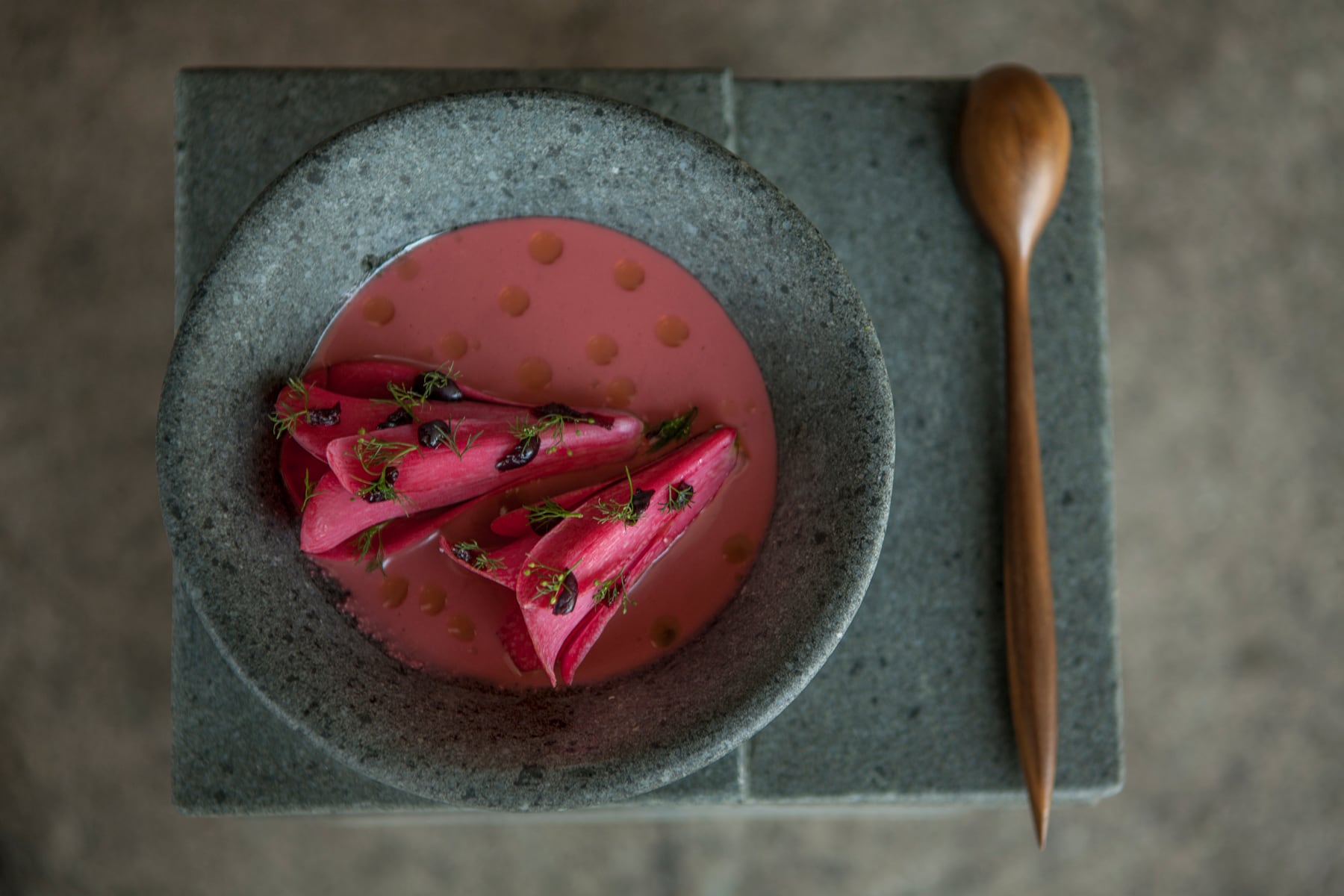 Plato de copihue, una flor nativa chilena, con ruibarbo y aceite de raíces (Boragó).