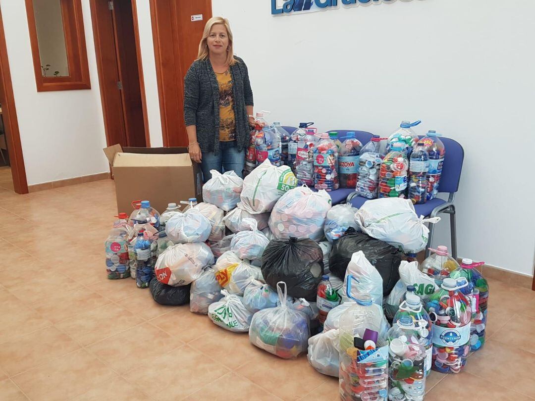 La concejal delegada de La Graciosa, Alicia Páez, junto a parte de los tapones recogidos.