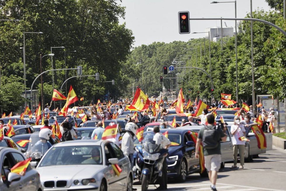 Coches y motos, con pancartas y banderas de España, circulan por las calles de la capital en la manifestación de Vox para pedir la dimisión del Gobierno de Pedro Sánchez
