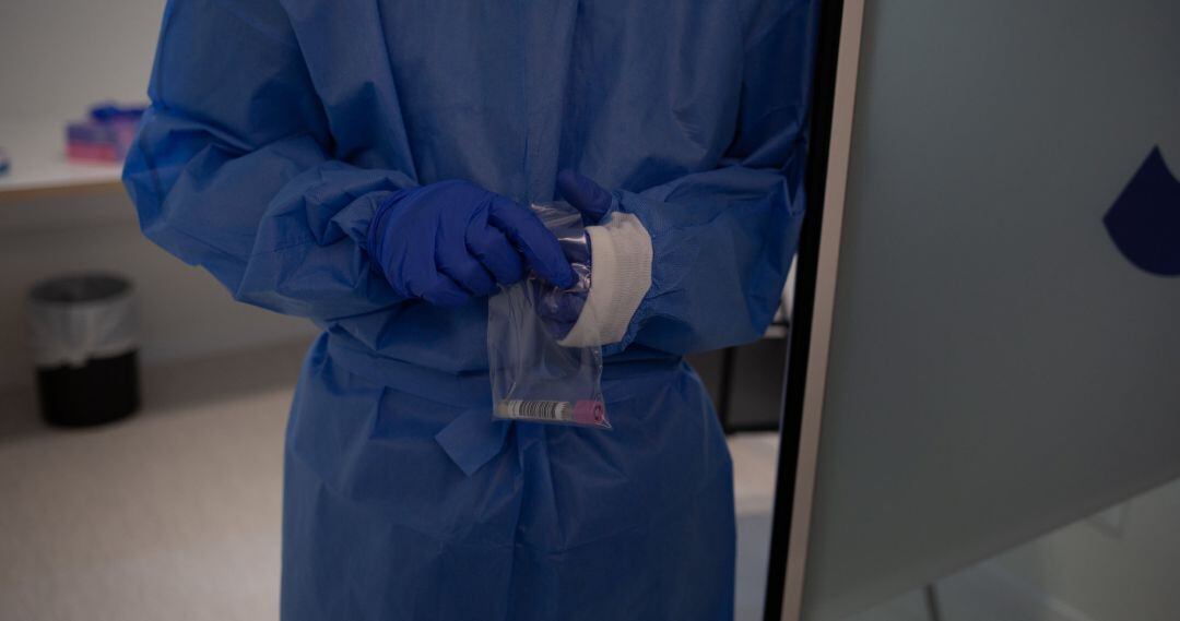 Archivo - Una profesional sanitaria sostiene muestras de pruebas PCR