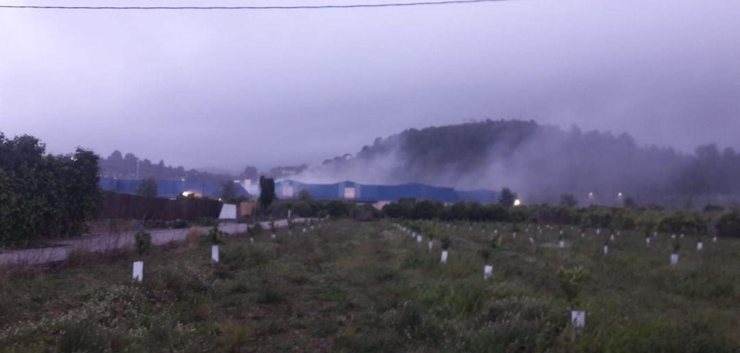 Almacén de Potries cubierto de humo durante el incendio 