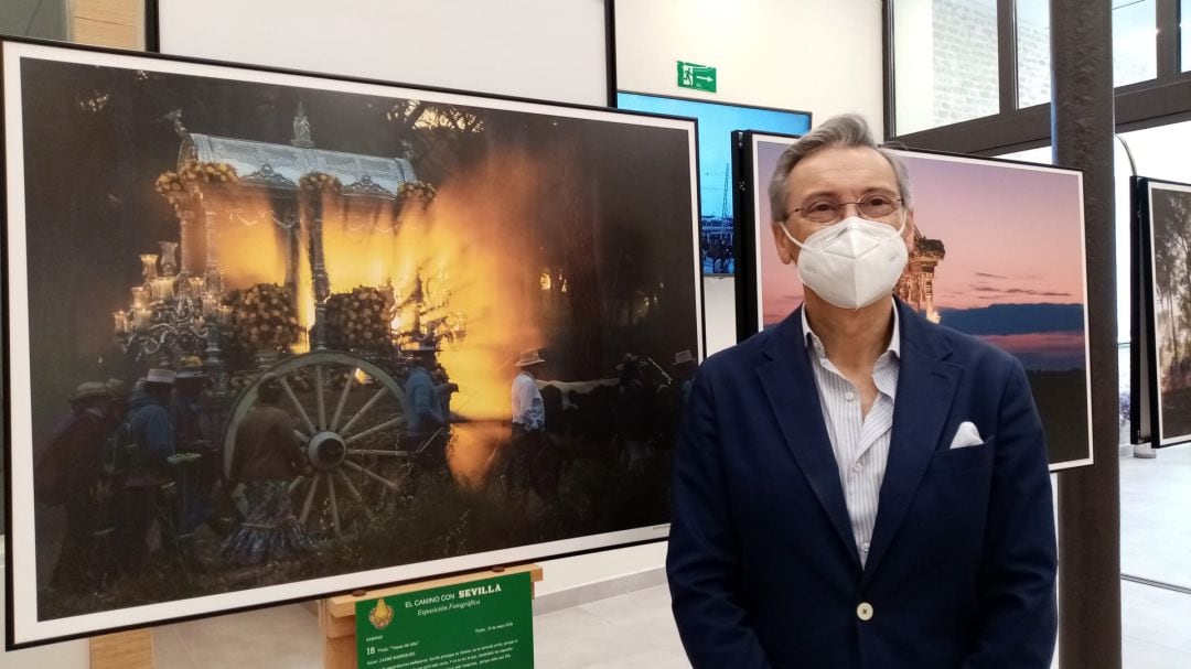 Gabriel Rojas, hermano mayor de la Hermandad del Rocío de Sevilla, posa ante una de las fotografías que se exponen en la muestra