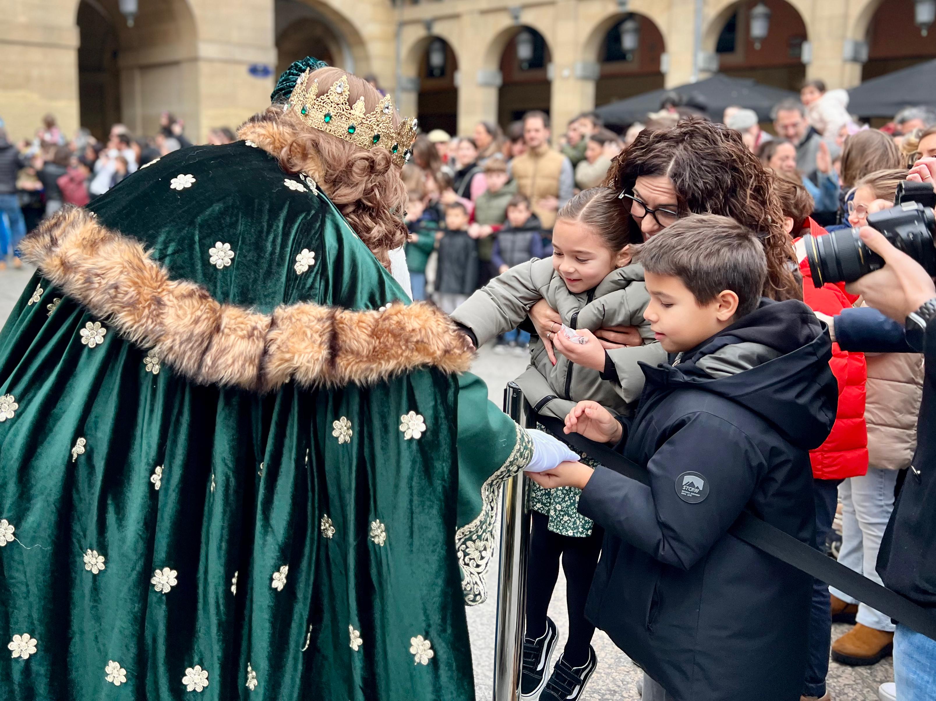 Gaspar reparte caramelos a un niño y una niña en Donostia