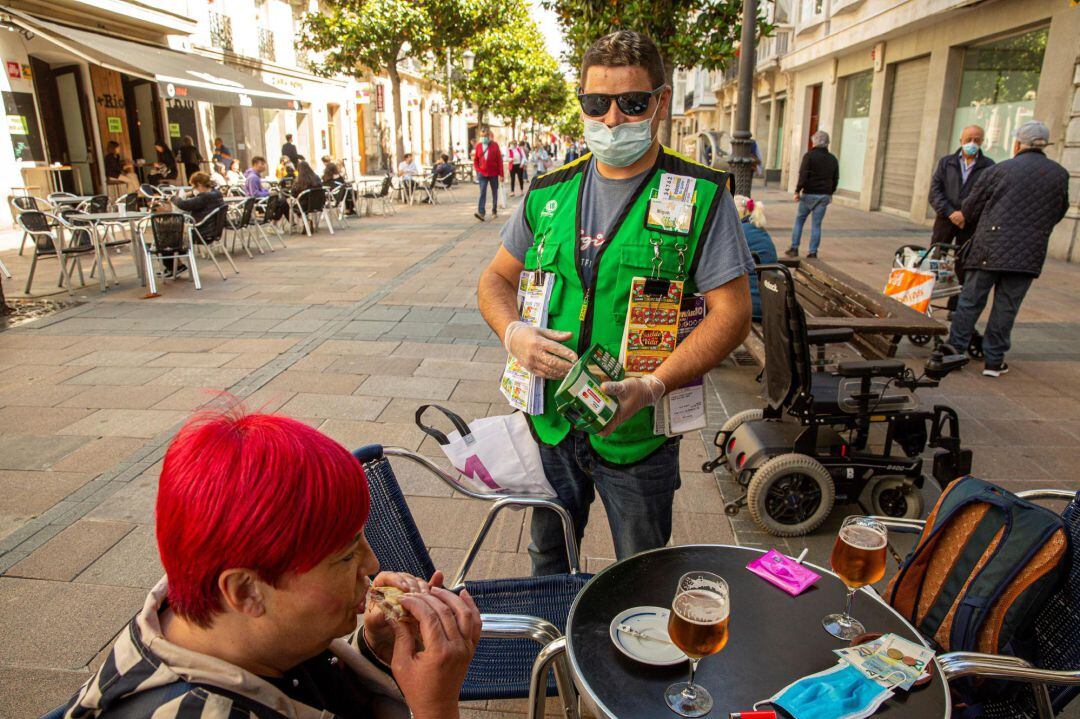 Un vendedor de la ONCE ofrece sus cupones en el centro de Vitoria