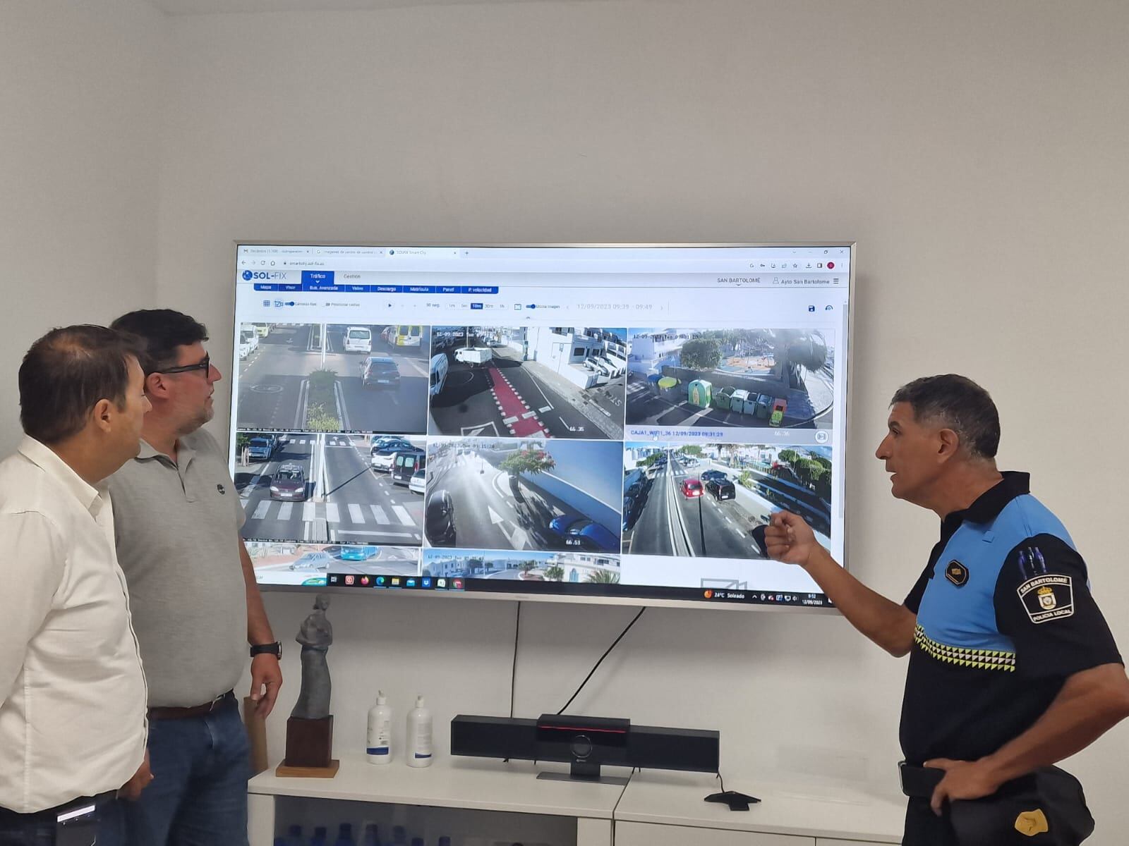 El alcalde de San Bartolomé, Isidro Pérez, junto al primer teniente de alcalde, Antonio Rocío, atendiendo a las explicaciones sobre las cámaras en la sede de la Policía Local.