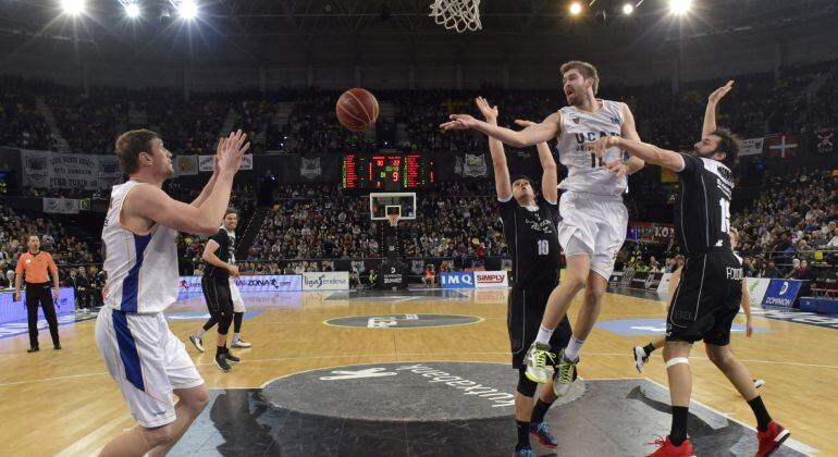 El alero del UCAM Murcia Nemanja Radovic (2d) entra a canasta ante varios jugadores del Dominion Bilbao Basket, durante el partido de la 19ª jornada de la Liga Endesa que se ha disputado hoy en el en el Bilbao Arena de Miribilla