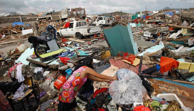 Una mujer busca sus pertenencias cerca de miles de casas dañadas después del paso del tifón 'Yolanda'