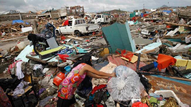 Una mujer busca sus pertenencias cerca de miles de casas dañadas después del paso del tifón 'Yolanda'