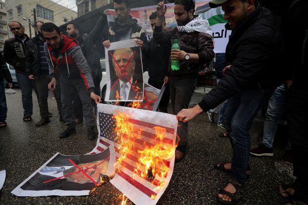 Varios palestinos queman una bandera estadounidense y de israel, e imágenes del presidente de EE.UU., Donald Trump, y del primer ministro israelí Benjamin Netanyahu