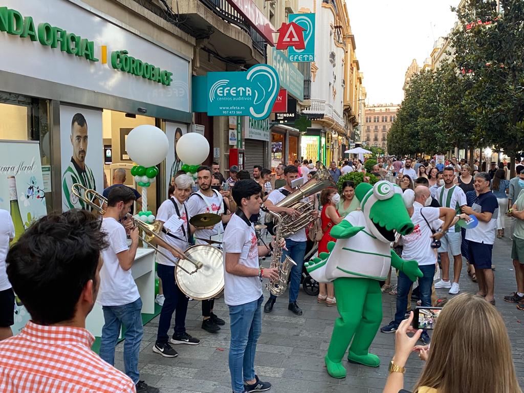 Koki, la mascota del Córdoba CF, junto a una banda de música frente a la tienda del club. Foto: Ángel Muñoz.