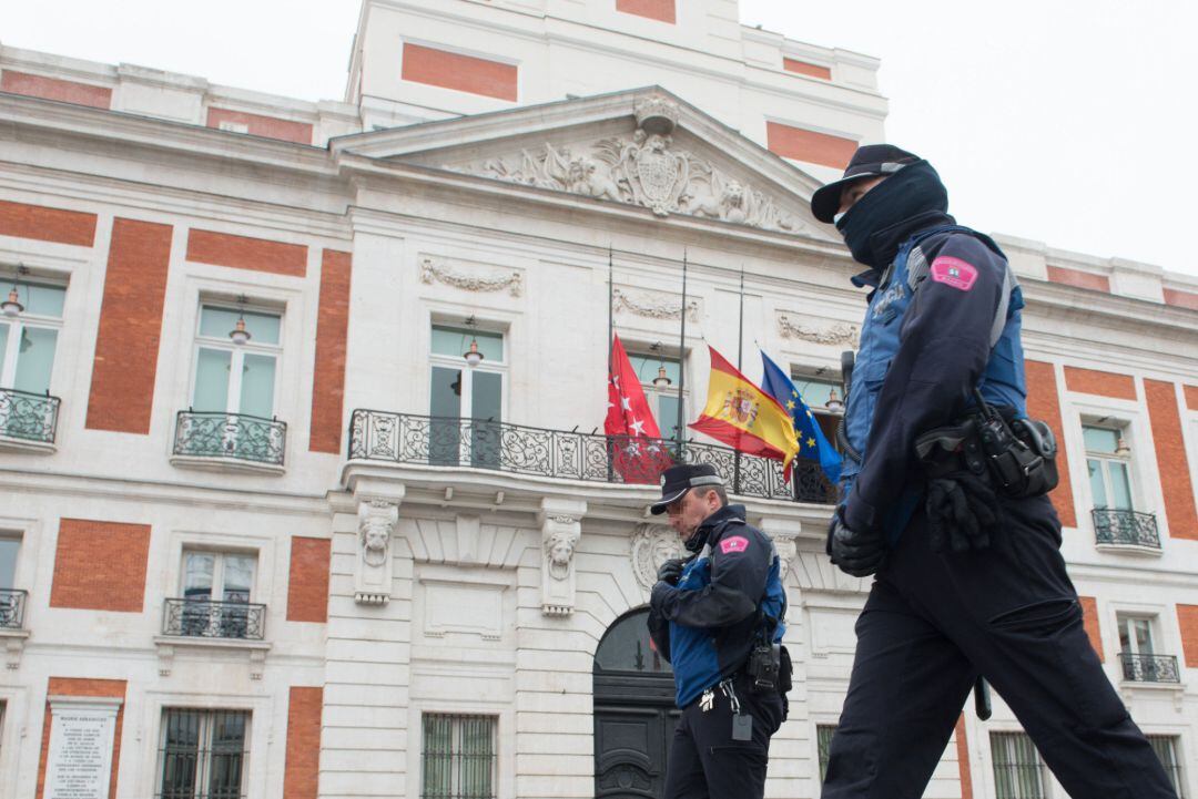 Dos agentes de la Policía caminan junto a la Real Casa de Correos