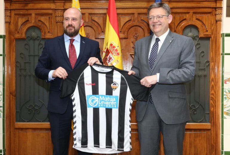 El president de la Generalitat, Ximo Puig, posa con la camiseta del CD Castellón que le ha regalado el presidente del club, David Cruz.