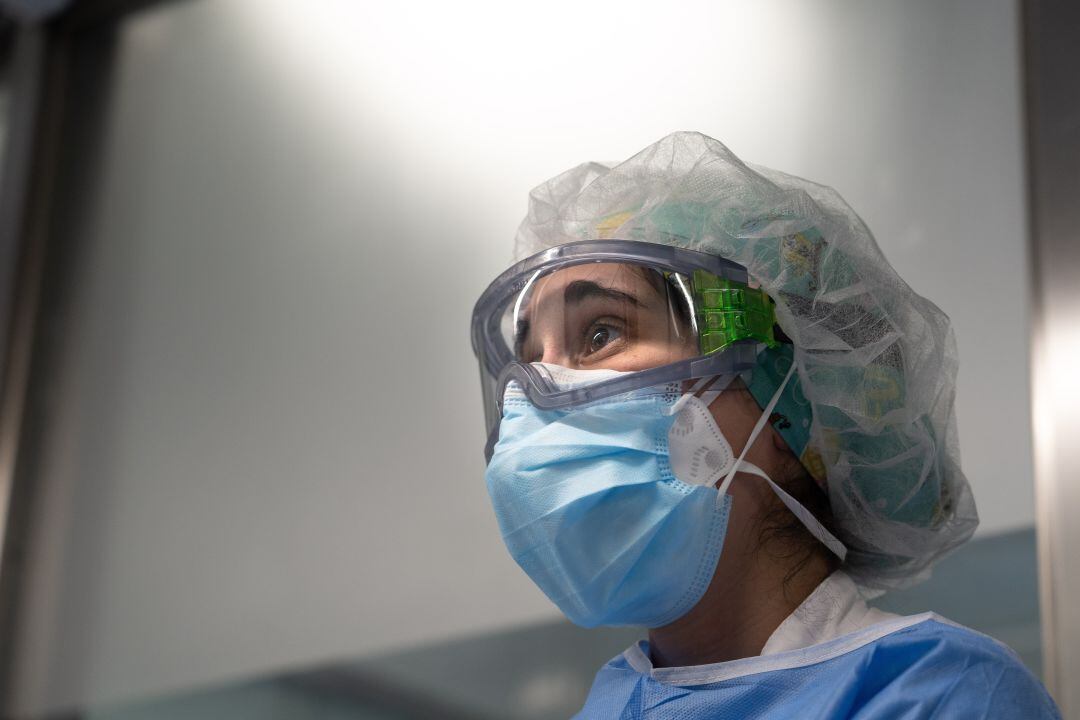 Una sanitaria se prepara para entrar en una UCI a atender pacientes COVID. 