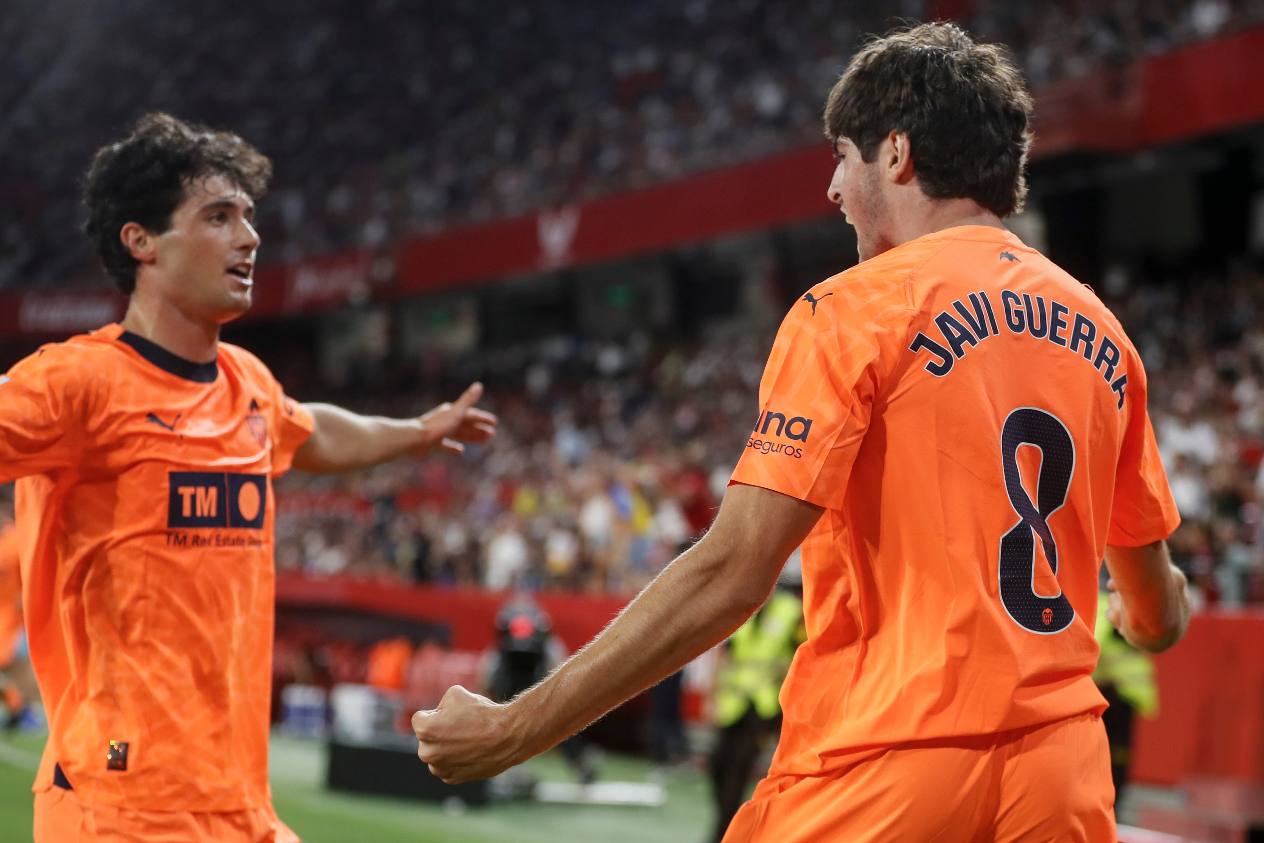 SEVILLA, 11/08/2023.- El delantero del Valencia Javi Guerra (d) celebra con Gonzalbez Gilabert tras marcar el segundo gol ante el Sevilla, durante el partido de LaLiga disputado este viernes en el estadio Sánchez Pizjuán, en Sevilla. EFE/José Manuel Vidal
