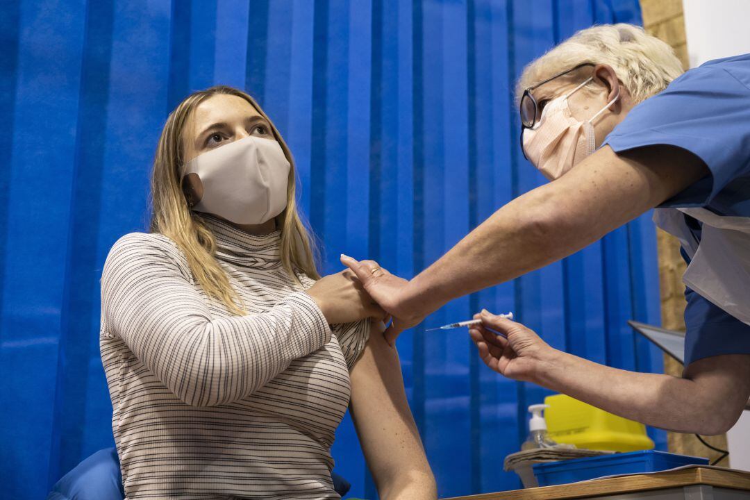 Una mujer recibe la vacuna de Pfizer en un centro de vacunación en Cardiff