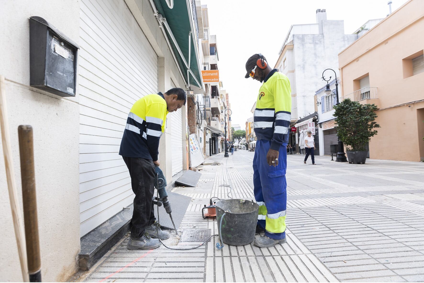 Unos operarios trabajan en la calle Verge del Grau de Gandia.