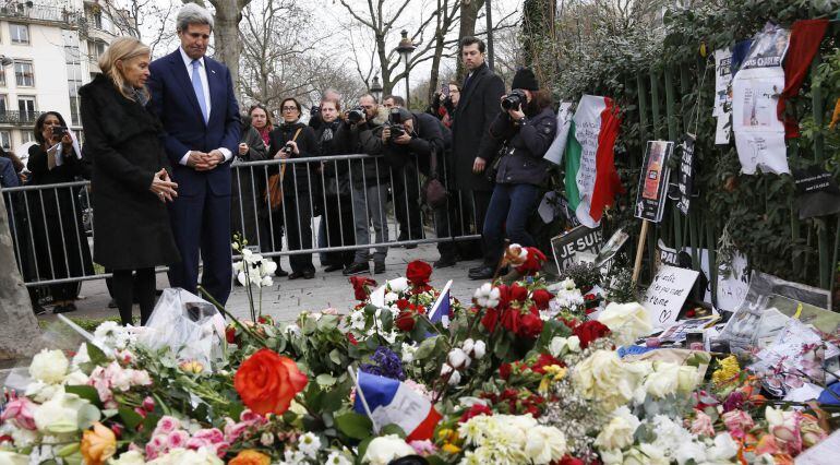 U.S. Secretary of State John Kerry pauses after laying a bouquet of flowers at a memorial at the site where a police officer was murdered in an attack at the Charlie Hebdo newspaper in Paris January 16, 2015. At left is U.S. Ambassador to France Jane Hart