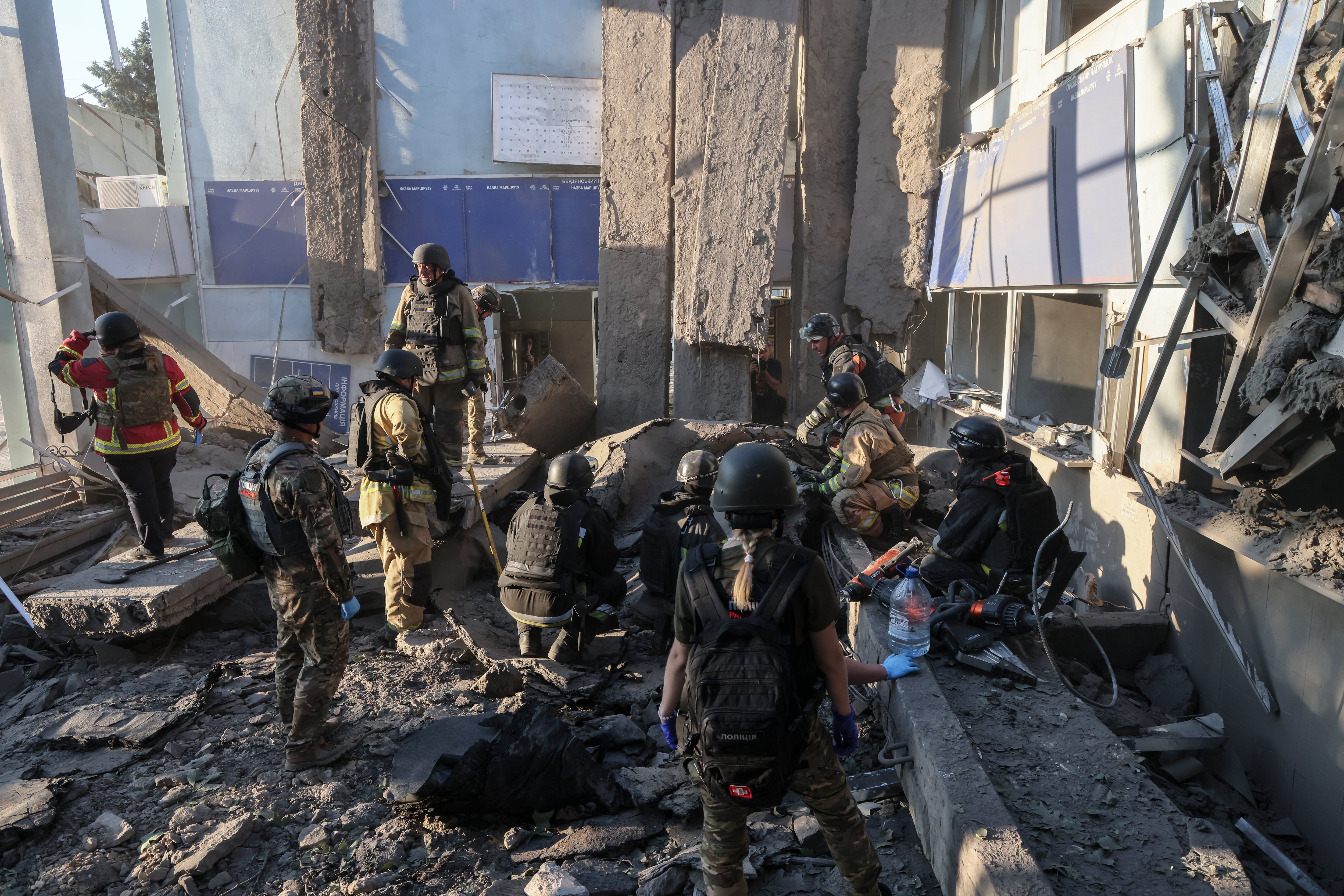 Rescatistas y policías ucranianos trabajan en el lugar del ataque ruso a una estación de autobuses en Zaporiyia, Ucrania, este domingo.