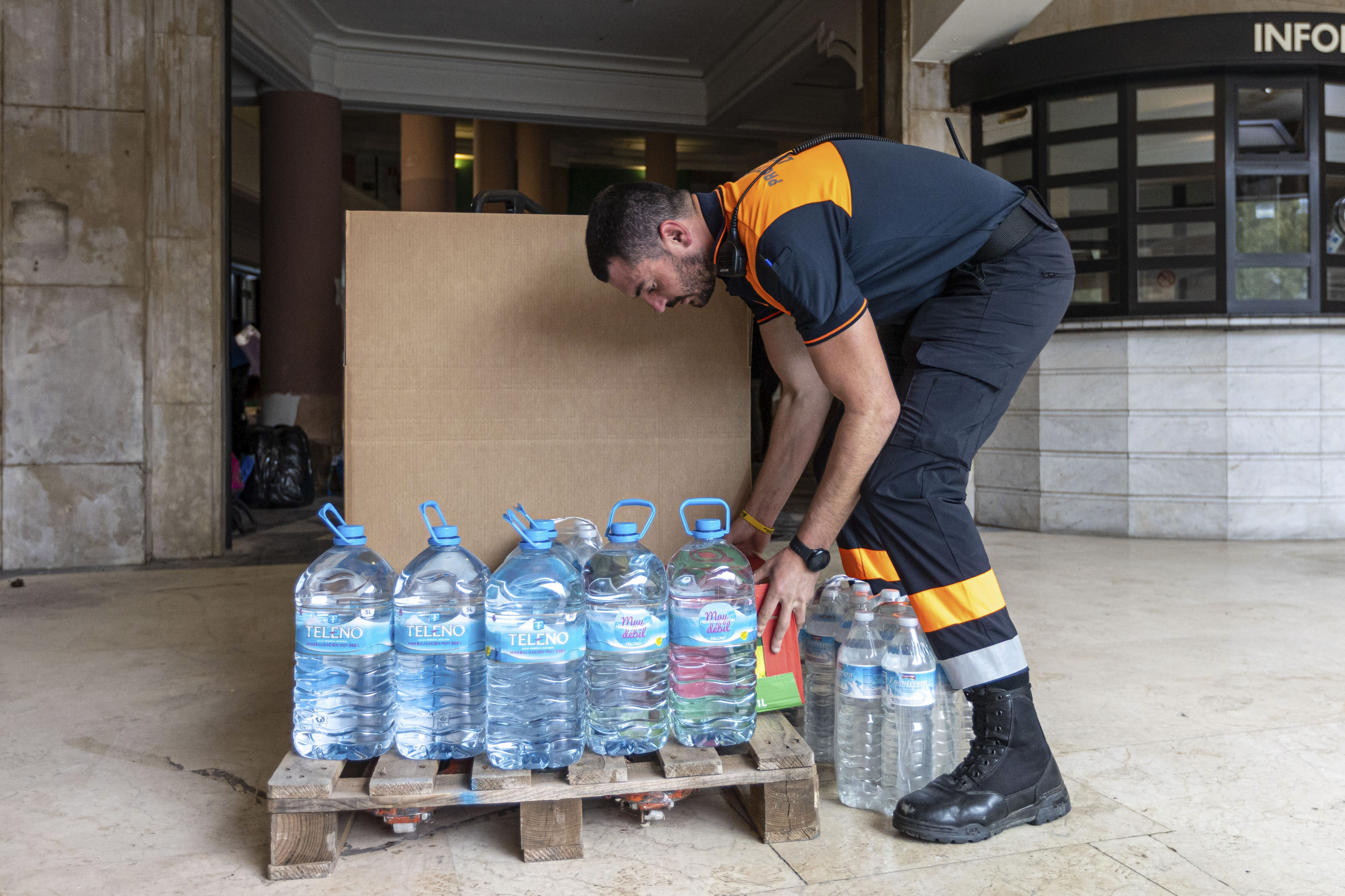 LOGROÑO 02/11/2024.- Un miembro de Protección Civil apila garrafas de agua en la antigua Estación de Autobuses de Logroño, reconvertida desde este sábado, en punto de recogida de material para los afectados por el desastre ocasionado por las inundaciones de la DANA. La Federación Riojana de Municipios (FRM) y el Ayuntamiento de Logroño han organizado este dispositivo de ayuda de los municipios riojanos, en coordinación con las federaciones Española y Valenciana de Municipios. EFE/Raquel Manzanares
