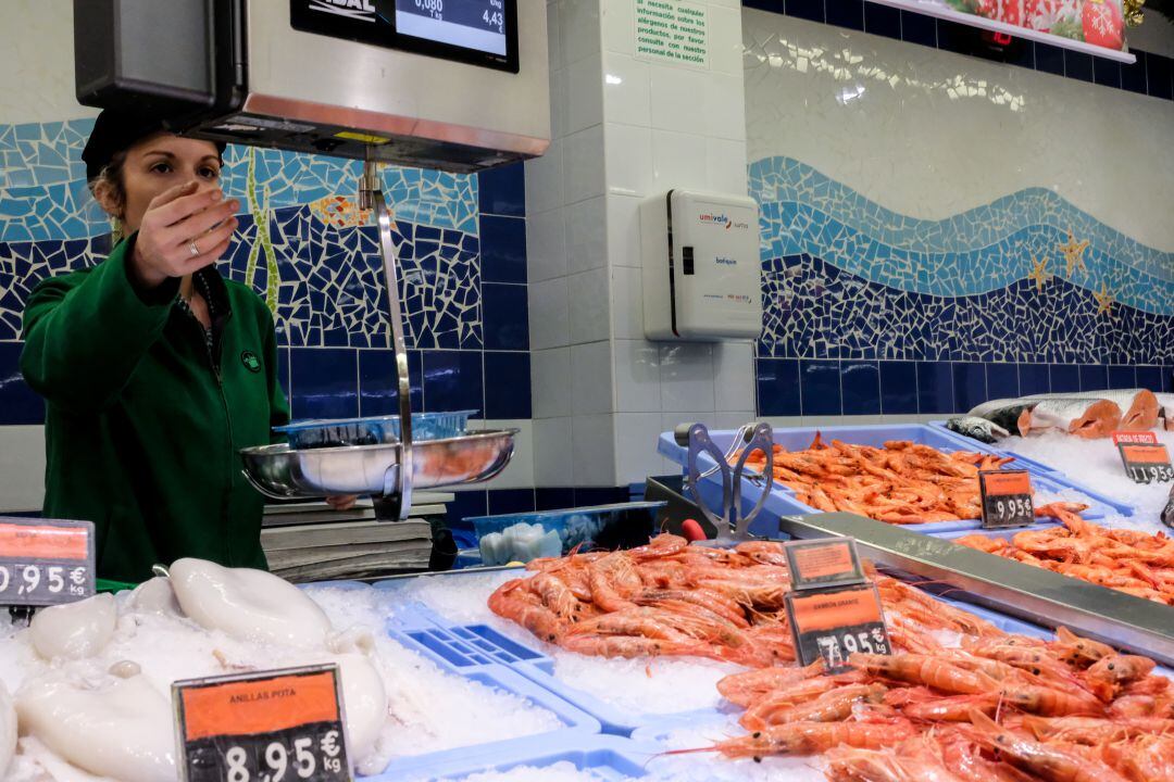 Una trabajadora atiende en la pescadería de un supermercado