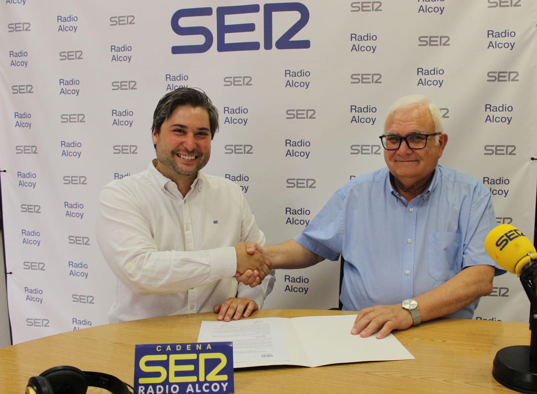Javier Expósito, presidente de Jovempa, y Juan Jordá, director de Radio Alcoy, durante la firma del convenio en el estudio central de Radio Alcoy