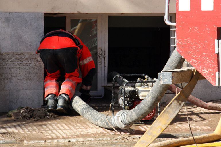 Un bombero retira el agua del semisótano desde una ventana de la residencia geriátrica de Agramunt.