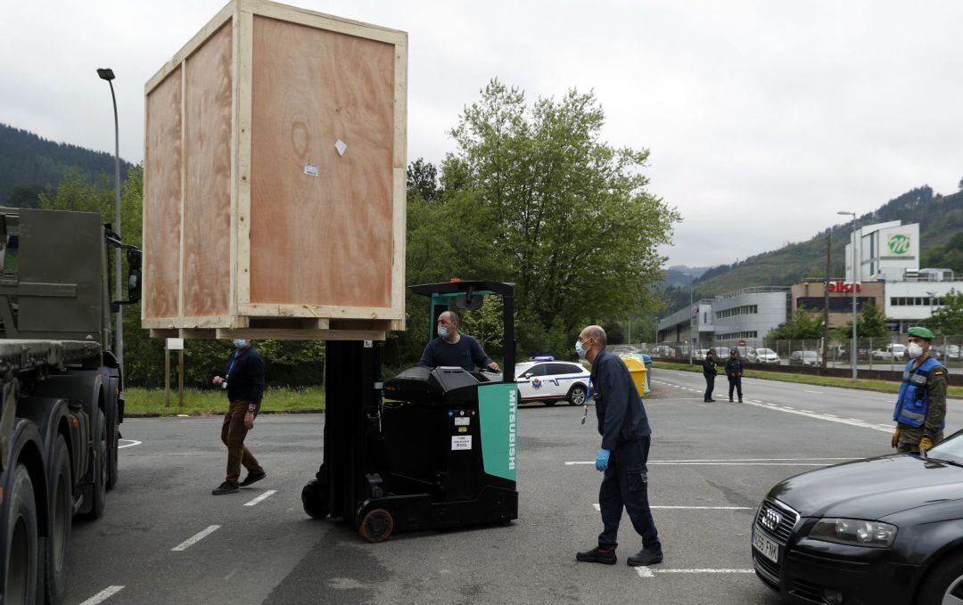 Miembros del ejército y personal del la empresa Bexen Medical, en la localidad vizcaína de Etxebarria, durante la descarga de tres máquinas procedentes de China, que fabricarán mascarillas para el Ministerio de Sanidad.