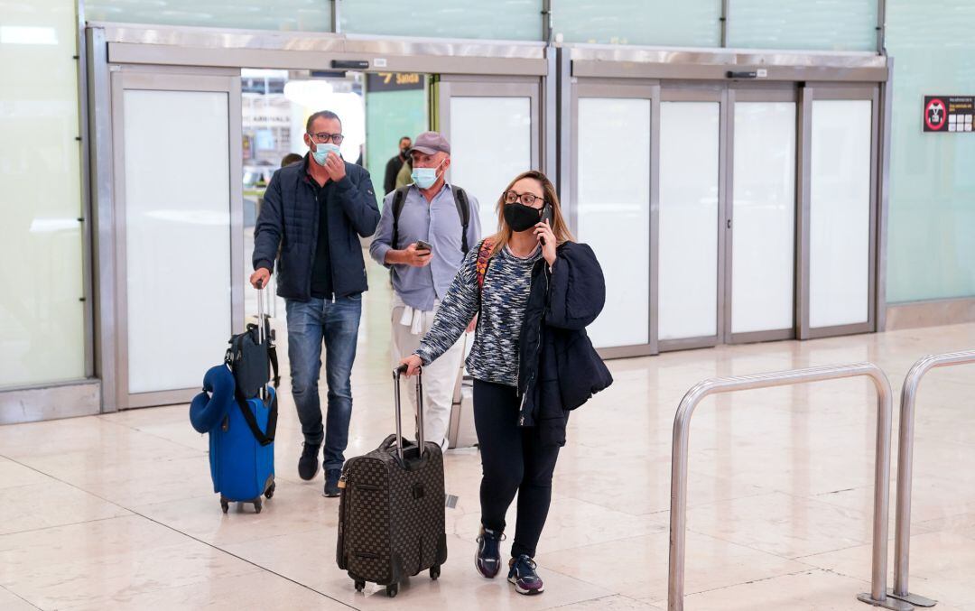 Archivo - Varias personas en la T4 del aeropuerto Adolfo SuárezMadrid-Barajas.