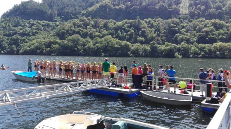 Nadadores, nadadoras, en el embarcadero para participar en la travesia a nado de Os Peares