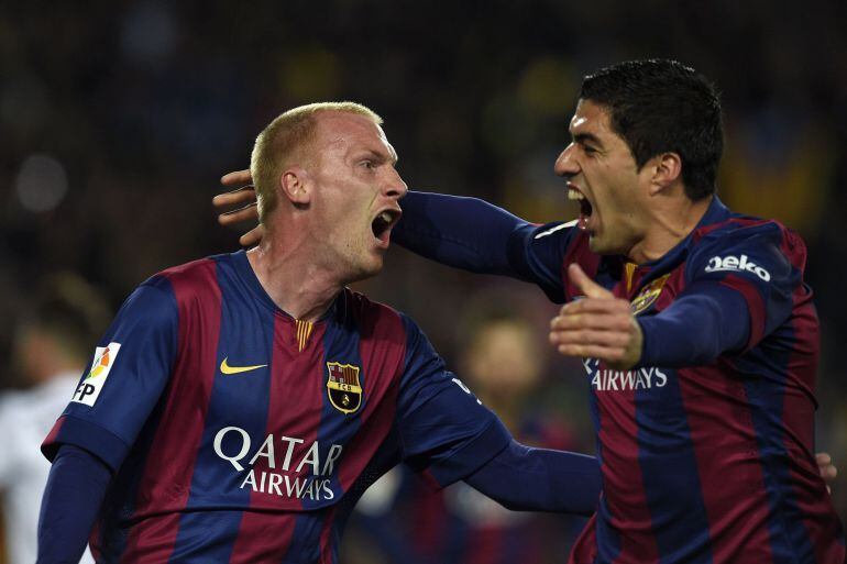 TOPSHOTS Barcelona's French defender Jeremy Mathieu (L) and Barcelona's Uruguayan forward Luis Suarez celebrate after scoring a goal during the "clasico" Spanish league football match FC Barcelona vs Real Madrid CF at the Camp Nou stadium in Barcelona on March 22, 2015.    AFP PHOTO / LLUIS GENE