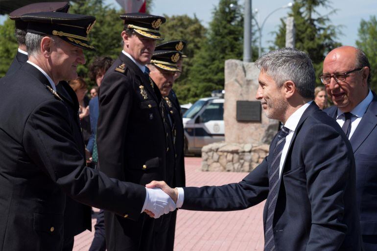 El ministro del Interior, Fernando Grande-Marlaska, acompañado por el director general de la Policía, Germán López, saluda al director de la Escuela Nacional de Policía de Ávila, José Luis Tejedor, en el acto de jura del cargo de la nueva promoción. 